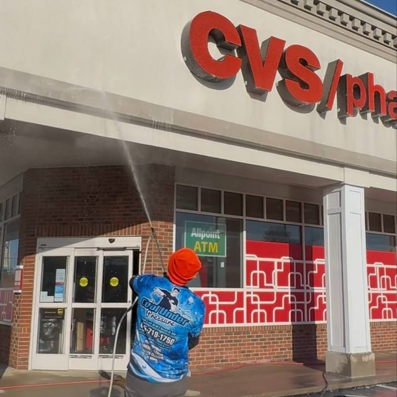 Cool Under Pressure technician pressure washing the CVS storefront exterior in Dickson, TN