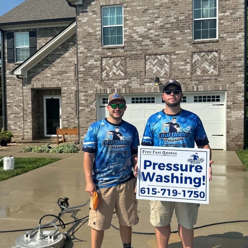 Cool Under Pressure team holding a yard sign outside a freshly washed home in Dickson, TN